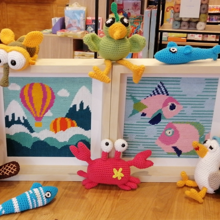 Alignement de plusieurs boîtes de kits amigurumi de la collection Kakapo Store.